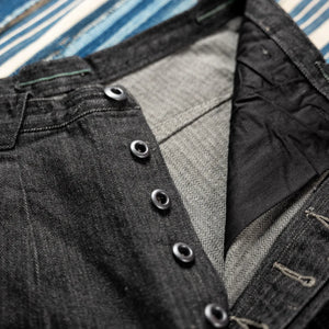 MotivMfg Pleat Herringbone Denim Trousers Black Classic Straight close up button fly
