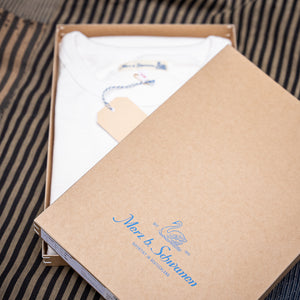 Ein weißes Merz b. Schwanen T-Shirt in der Verpackung. 